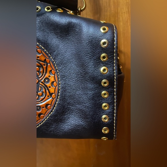 Black leather cross body purse with orange colored medallion on front. - Picture 8 of 14